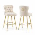 Taburetes de terciopelo crema con patas de metal dorado